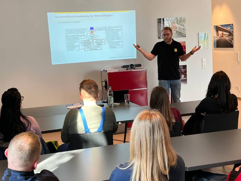 Mann präsentiert vor Publikum.