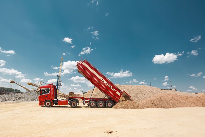 Sattelkipper Baustelle roter Lkw blauer Himmel 